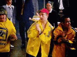 a man wearing a yellow jacket with a t on it