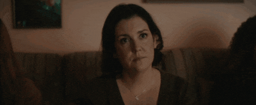a woman is sitting on a couch looking at something