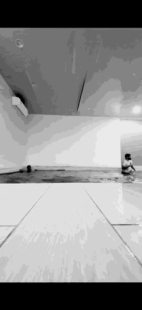 a black and white photo of a child playing in a pool .