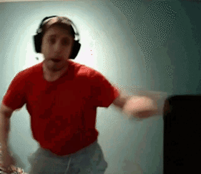 a man in a red shirt and headphones is dancing