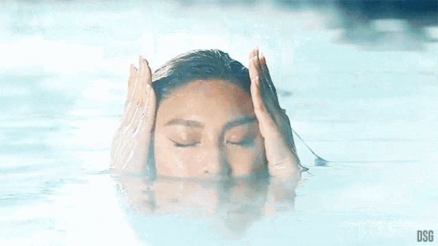 a woman with a tattoo on her arm is swimming in a pool