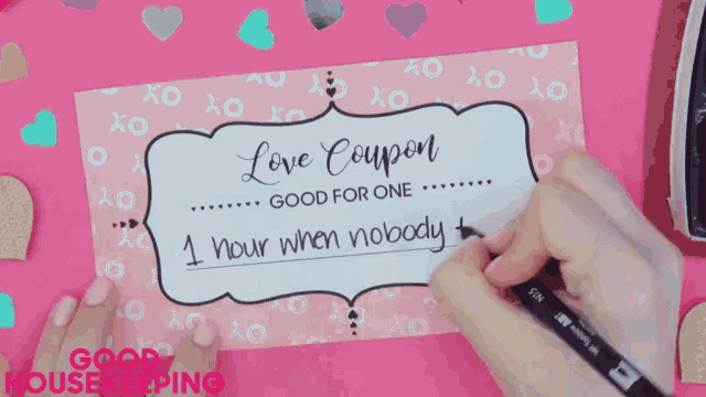 a person is writing a love coupon on a pink background