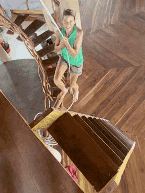 a woman is walking up a set of wooden stairs .