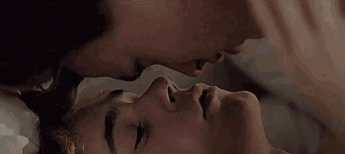 a man and a woman are kissing on a bed
