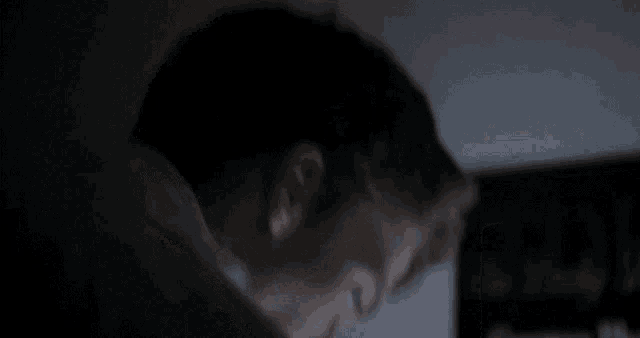 a man 's head is shown in a dark room
