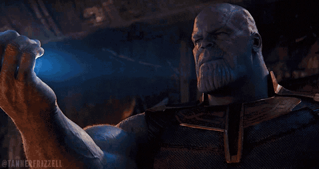 thanos from avengers infinity war is surrounded by blue smoke and light