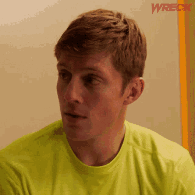 a man wearing a yellow shirt with the word wreck on the bottom right
