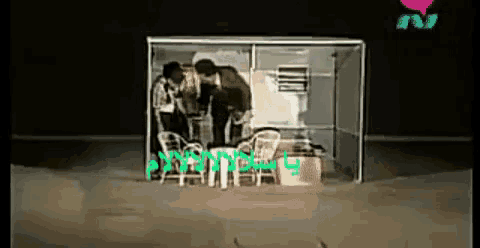 a group of people are standing in a room with a sign that says ' nn ' on it