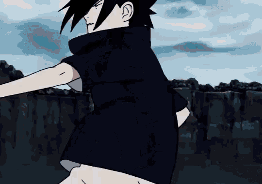 a boy in a black shirt is standing in front of a rock wall .