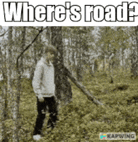 a man standing in a forest with the words where 's road written above him