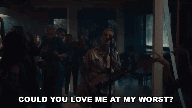 a man singing into a microphone with the words " could you love me at my worst " above him