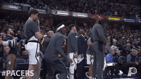 a group of basketball players are standing in front of a crowd with advertisements for motorola and gatorade