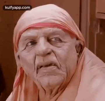 a close up of an elderly woman wearing a scarf on her head .