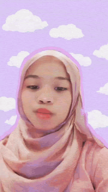 a woman wearing a hijab and a pink shirt is standing in front of a purple background with clouds