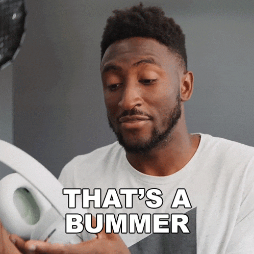 a man holding a pair of headphones with the words that 's a bummer behind him