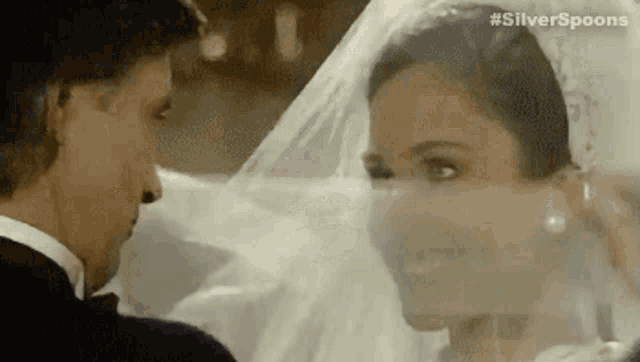 a bride and groom are looking into each other 's eyes .