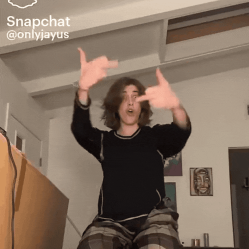 a man is dancing in a room with a snapchat sticker on the ceiling