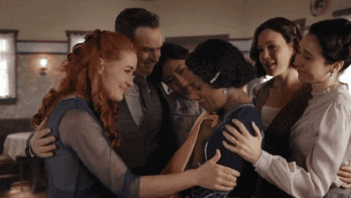 a group of women are hugging each other in a circle