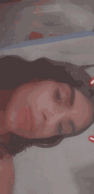 a close up of a woman 's face with a red heart in the corner