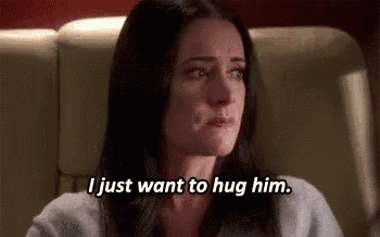 a woman is crying while sitting in a chair and saying `` i just want to hug him . ''