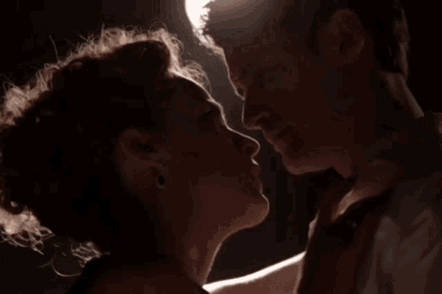 a man and woman are kissing in the dark