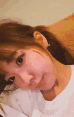 a close up of a woman laying on a bed with her eyes closed