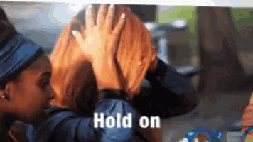 a woman is holding another woman 's head with the words hold on written on the bottom
