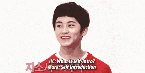 a young man in a red shirt is smiling while talking to another young man .