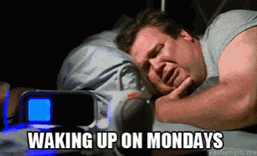 a man is laying in bed with the words waking up on mondays on the bottom