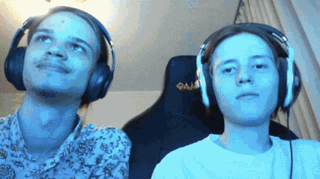 two people wearing headphones one of whom is wearing a chair with the word game on it