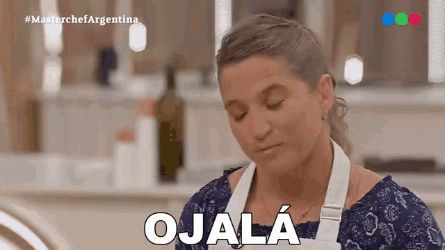 a woman in an apron is making a funny face and says ojalá
