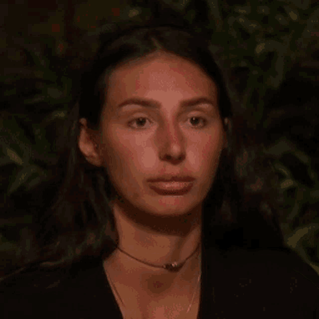 a close up of a woman 's face with a choker around her neck