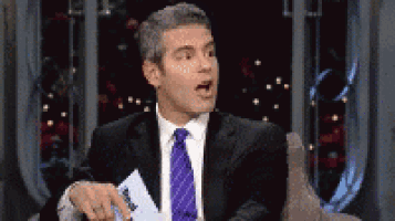 a man in a suit and tie is holding a piece of paper that says abc