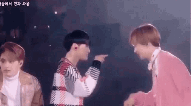 two young men are standing next to each other on a stage .