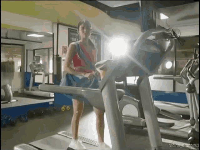 a woman is running on a treadmill in a gym with a sign on the wall that says today
