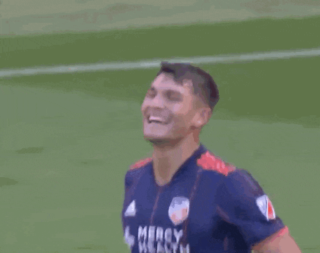 a soccer player wearing a mercy health jersey is laughing and celebrating .