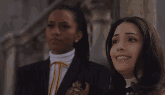two women standing next to each other and smiling