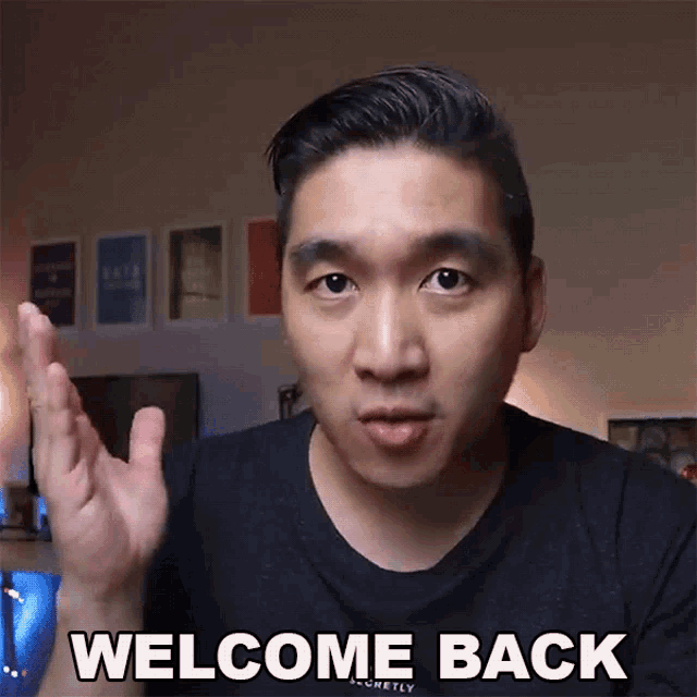 a man in a black shirt says welcome back with his hands up