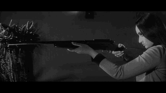 a woman holding a gun in a black and white photo