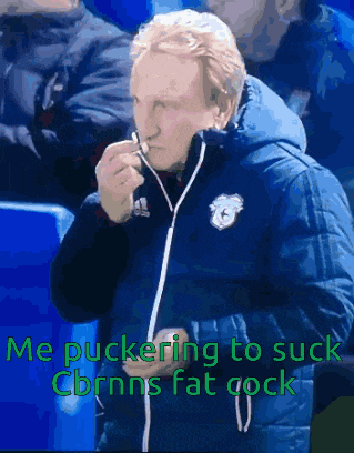 a man in a blue jacket smoking a cigarette with the words me puckering to suck cbnns fat cock above him