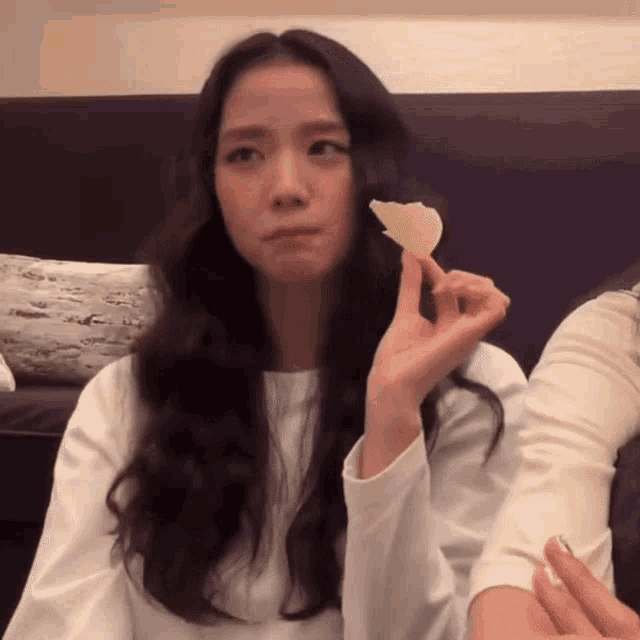 a woman with long hair is holding a slice of potato chips