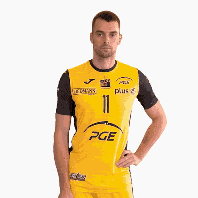 a man wearing a yellow and black pge shirt