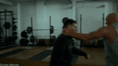a man is being punched in the face by another man in a gym that says screen master on the bottom