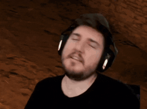 a man with a beard wearing headphones is making a funny face