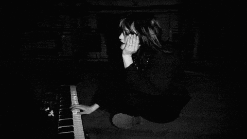 a black and white photo of a person playing a piano