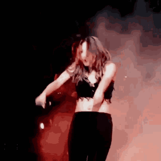 a woman is dancing on stage with a microphone in her hand .