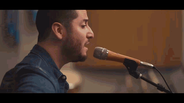 a man is playing an acoustic guitar with the letter s on the frets