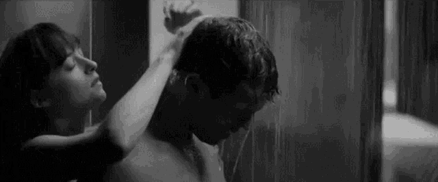 a man and a woman are taking a shower together .