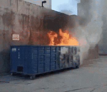a dumpster is on fire and has a sign that says " do not enter "