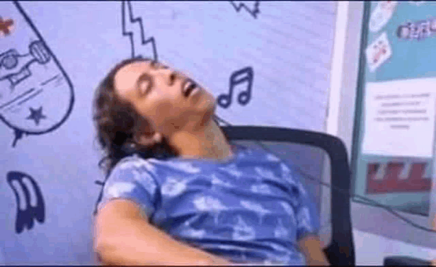 a man is sleeping in a chair in front of a wall with a drawing of a skateboard on it .